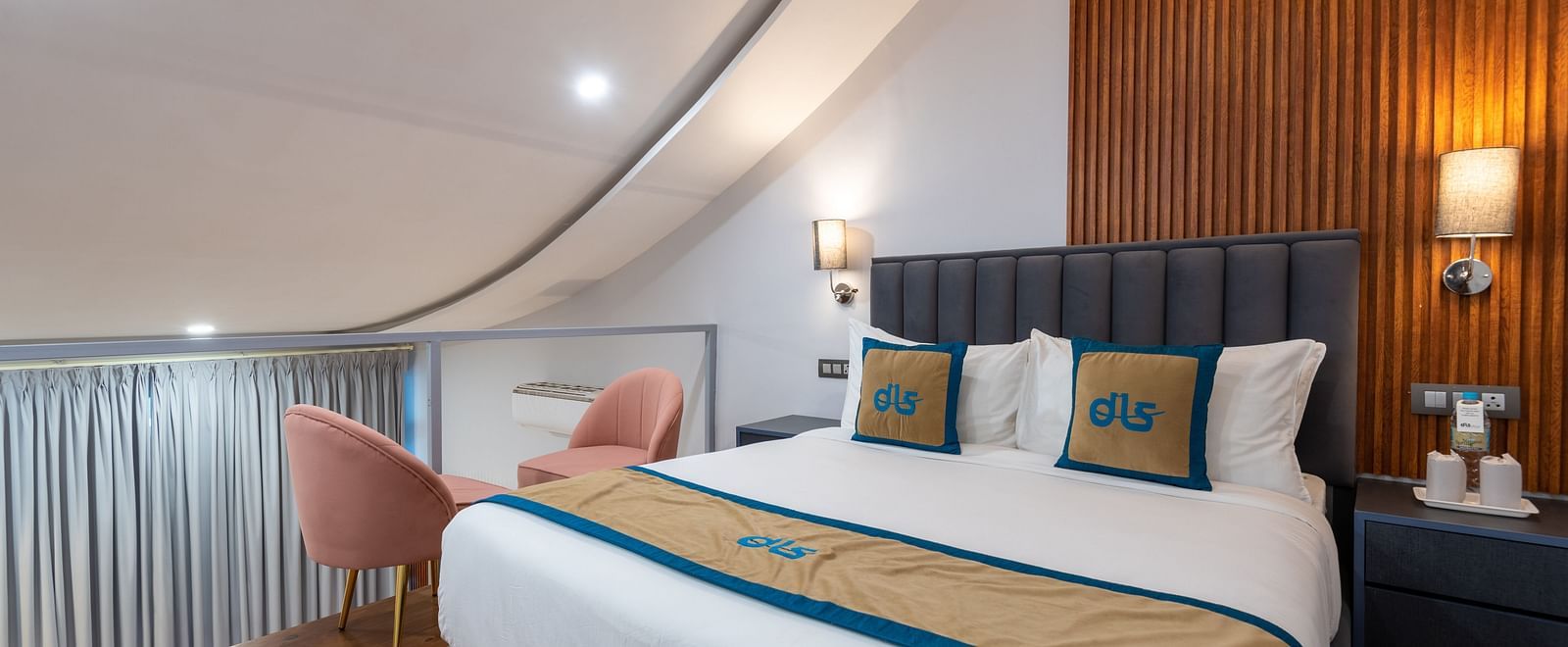 Spring Duplex Room at DLS Spring  Valley resort Dharamshala on the second story featuring a king bed table, chairs and a  bed lamp